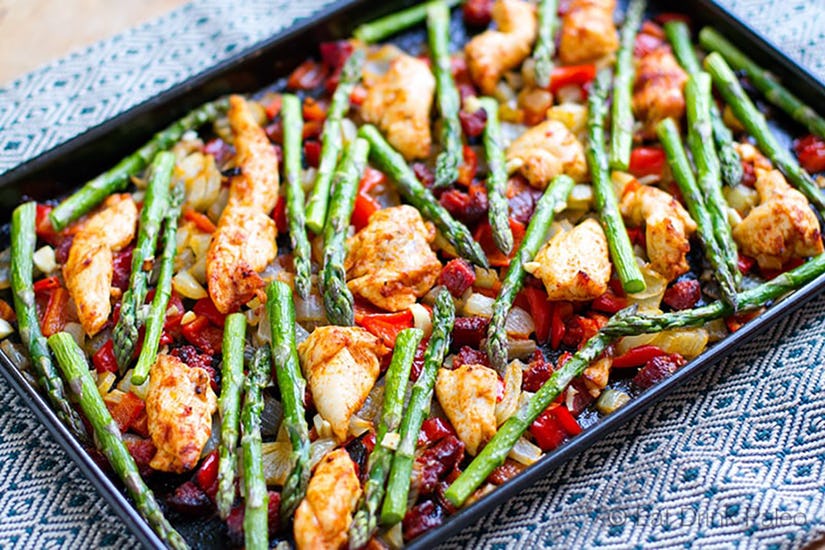 Roasted chicken and vegetables on baking sheet.