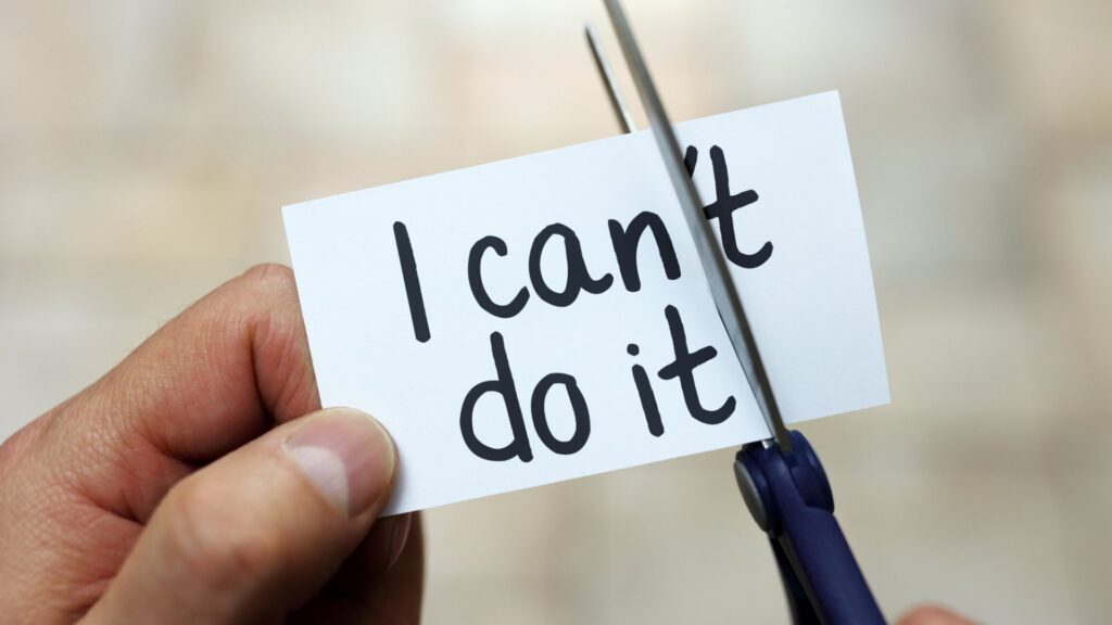 Hand cutting "I can't do it" note to say "I can.