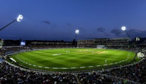 Nighttime cricket match at a well-lit stadium.