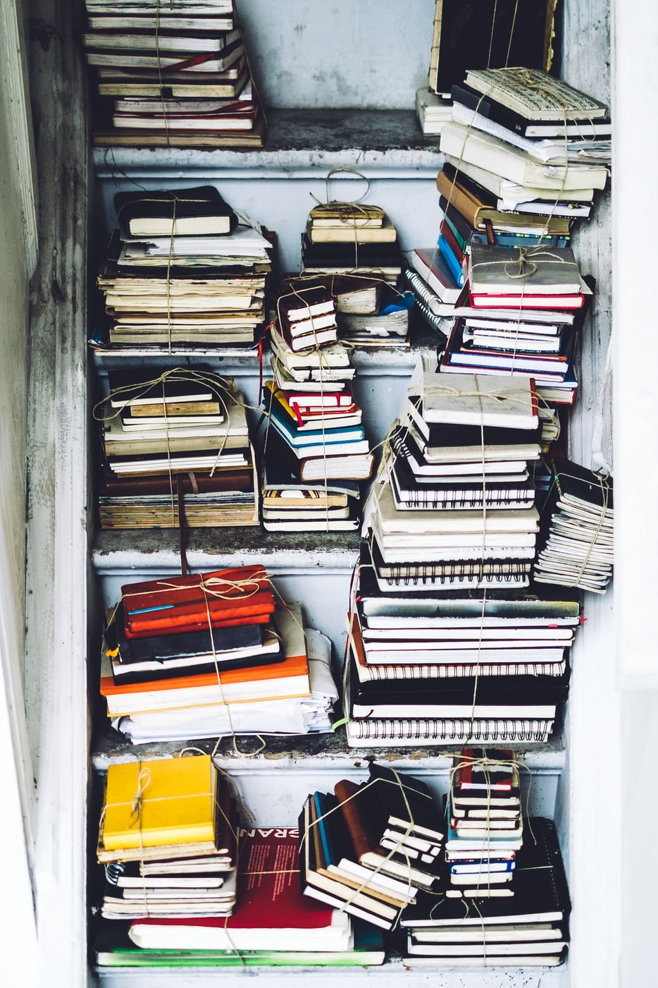 Stacked books in various sizes on shelves.