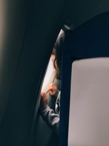 Person looking out airplane window.