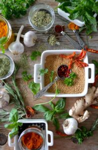 Various fresh herbs and spices on wooden table.