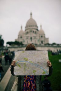 Tourist with map facing Sacré-Cœur Basilica, Paris.