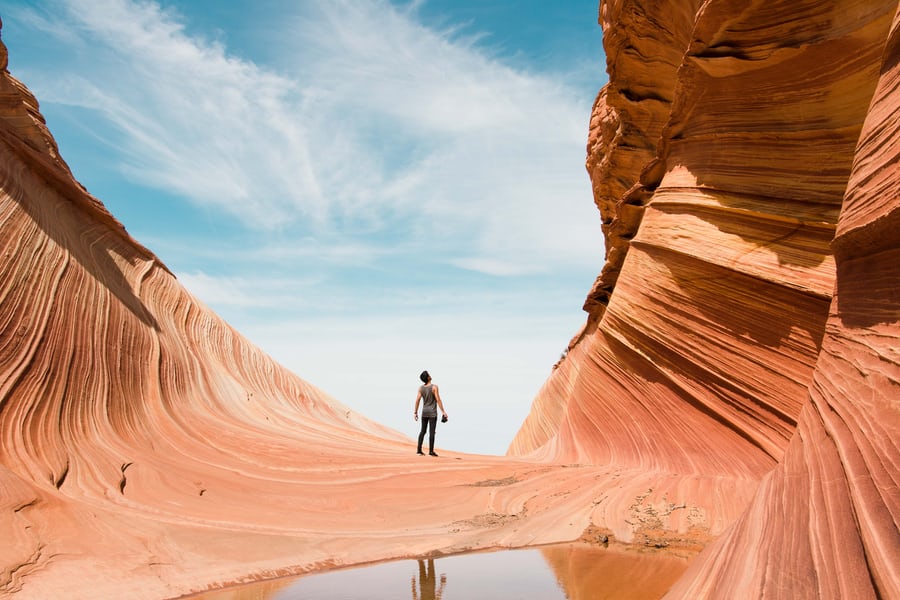 Person exploring majestic sandstone canyon landscape.