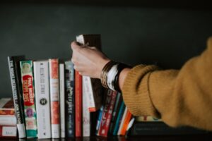 Person selecting a book from shelf