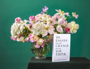 Colorful flowers and book on green background.