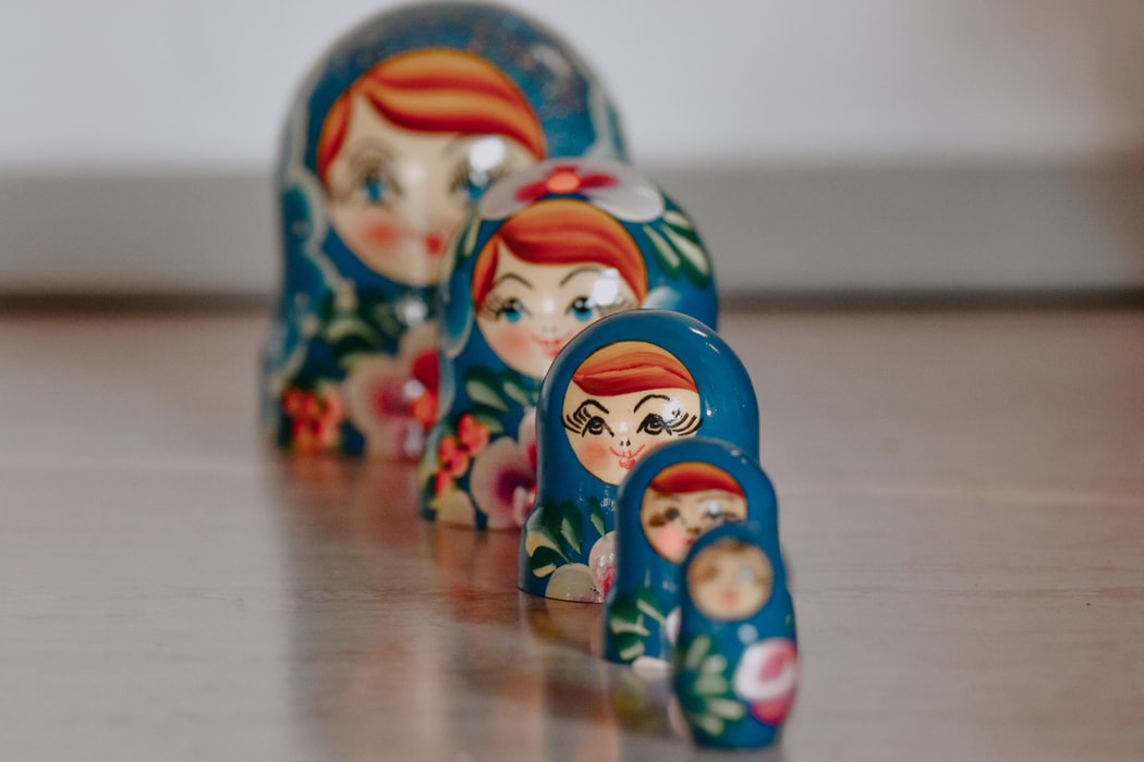 Line of colorful Matryoshka dolls on wooden surface.