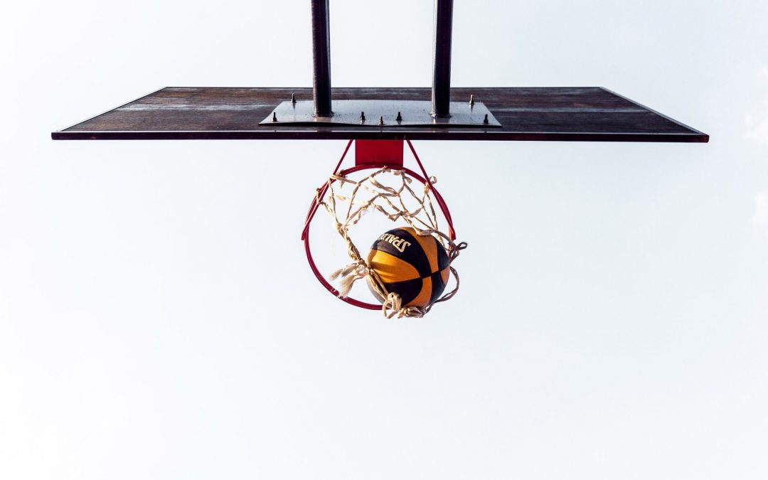 Basketball swishing through net in outdoor hoop.