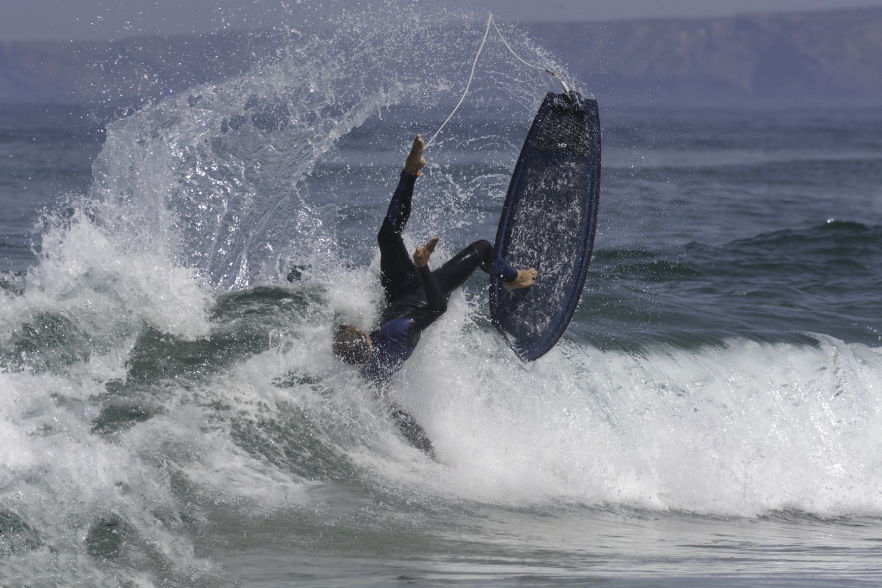 Surfer wiping out spectacularly on ocean wave.