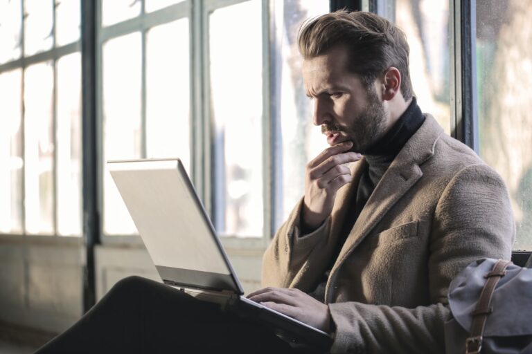 Man working on laptop in sunlit vintage room.