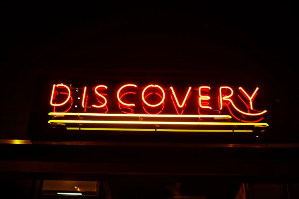 Neon sign spelling 'DISCOVERY' in red and yellow.