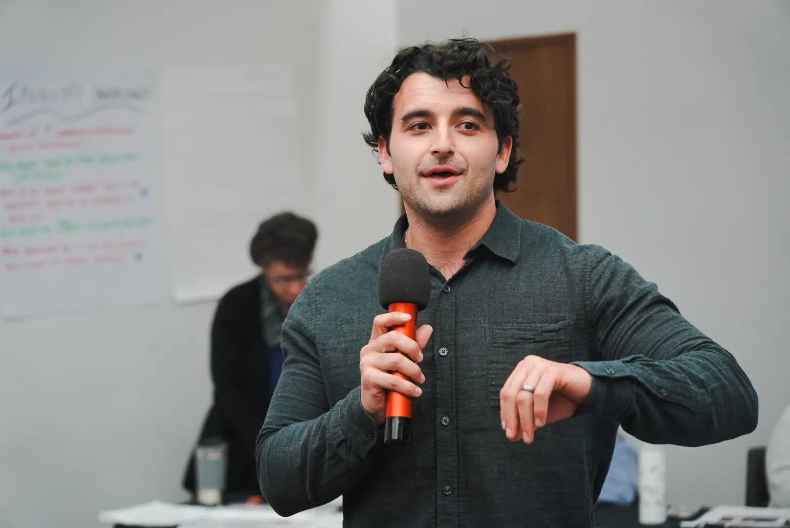 Man speaking into microphone at workshop