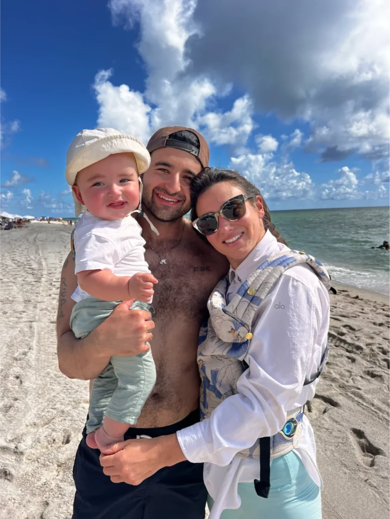 Family with toddler smiling on sunny beach