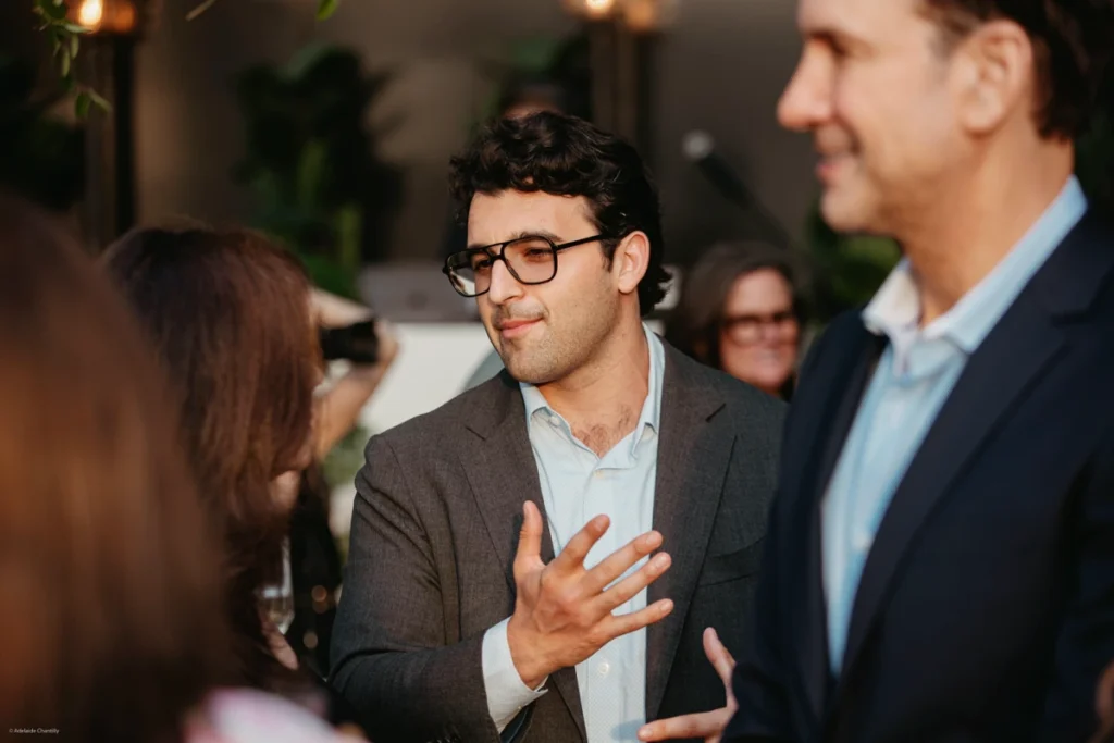 Man discussing with colleagues at evening event