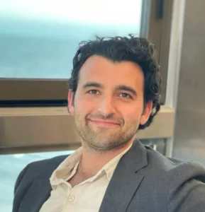 Smiling man in suit near window with sea view