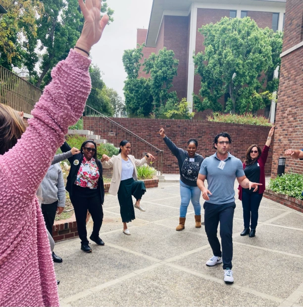 Group of diverse people dancing joyfully outdoors