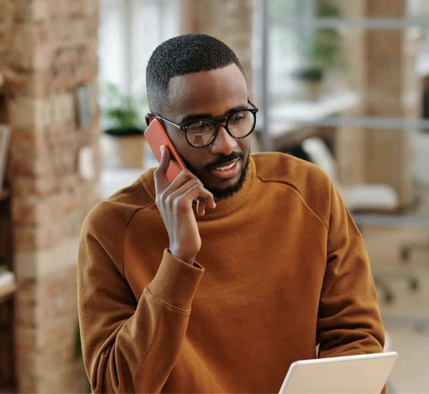 Man in glasses on phone holding tablet