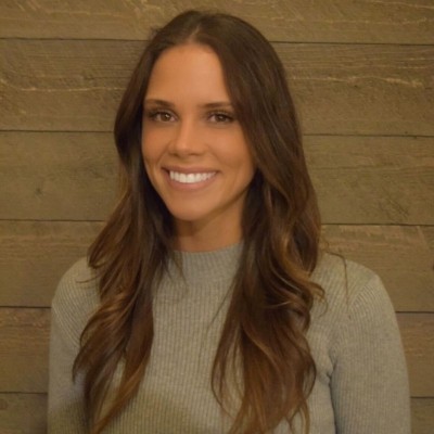 Smiling woman with long brown hair, green sweater