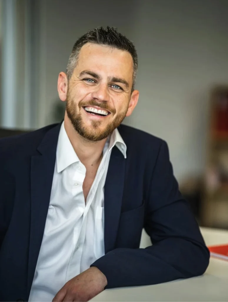 Smiling man in suit seated indoors