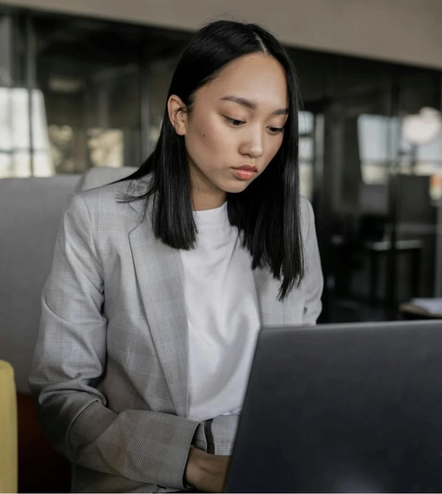 Focused woman working on laptop in modern office