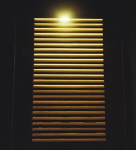 Illuminated window blinds in dark room